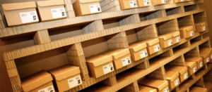 A photo of rows of brown shoeboxes on brown shelves
